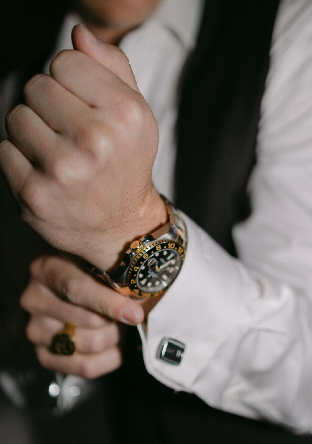 Man adjusting his cuff while wearing a two-tone luxury wristwatch